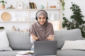 Teleconference. Smiling muslim woman having video call on laptop at home