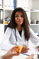 Wall Mural - Female medicine doctor hand hold jar of pills and write prescription to patient at worktable. Panacea and life save, prescribing treatment, legal drug store concept. Empty form ready to be used