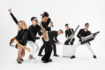 Entertaining concept, teamwork. International group of musicians on a white background, guitarist, drummer, soloists, saxophonist.