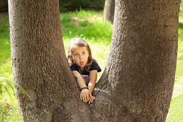 Bambina gioca con l'albero nel giardino di casa