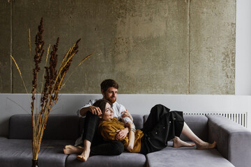 Young man and woman hug and kiss at home on the couch.