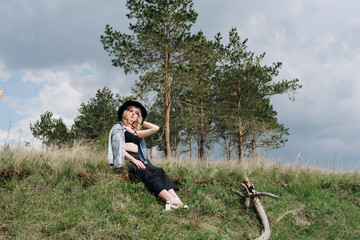 beautiful young woman in black against a landscape of sky and field