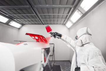 Man sprays white dye on the elements of the vehicle.