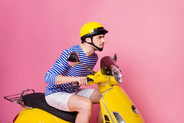 Wall Mural - Profile side view of his he nice attractive handsome focused concentrated guy driving moped hurrying up meeting appointment isolated over pink pastel color background