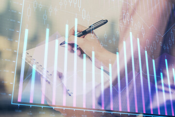 Multi exposure of hands making notes with forex chart huds. Stock market concept.