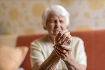 Senior woman with arthritis rubbing hands
