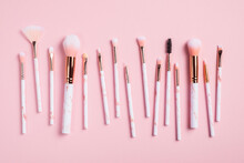 Professional Makeup Brushes Kit On Pink Background Top View.