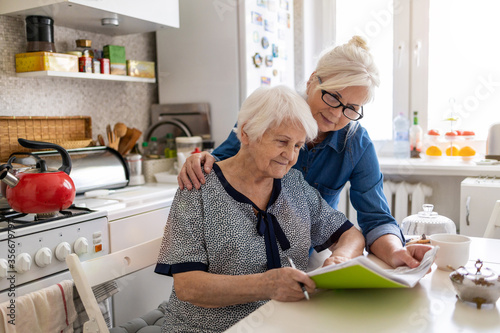 Cuadros en Lienzo Mature woman helping elderly mother with paperwork