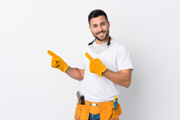 Poster - Craftsmen or electrician man over isolated white background pointing finger to the side