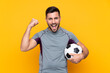 © luismolinero - Football player man over isolated background celebrating a victory