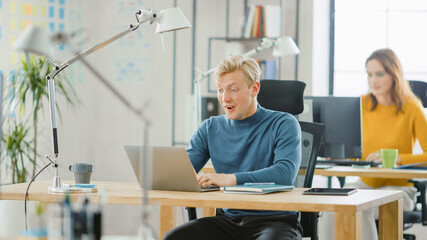 Aufkleber - Handsome Caucasian IT Specialist Sitting at His Desk works on a Laptop with Surprised Face after Sudden Success in Project. Diverse Team of Young Professionals Working in Office.