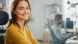 © Gorodenkoff - Portrait of Beautiful Young Woman with Red Hair Wearing Yellow Sweater Chats with Colleague and Turns Smilingly at Camera. Successful Woman Working in Bright Diverse Office.