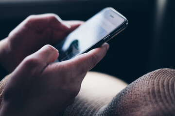 Closeup of hands holding the mobile phone for business and personal use. Selective focus. Copy space.