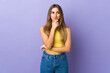 © luismolinero - Young woman over isolated purple background thinking an idea while looking up