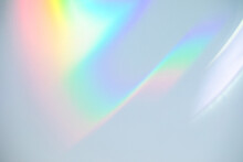 Blurred Rainbow Light Refraction Texture Overlay Effect For Photo And Mockups. Organic Drop Diagonal Holographic Flare On A White Wall. Shadows For Natural Light Effects