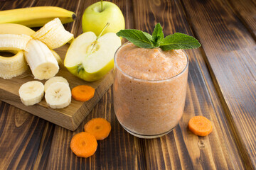 Wall Mural - Smoothies or puree with banana, apple, carrot  and  ingredients on the brown wooden  background