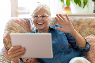 Sticker - Senior woman using digital tablet at home
