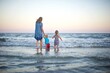 © Leslie Rodriguez - Mom and children playing in the ocean at sunset