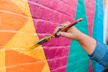 artist painting a wall with a brush