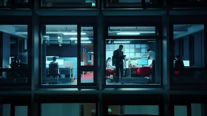 Poster - Footage from Outside the Window: Businessmen and Businesswomen Working in the Office. Managers and Specialists Doing Financial Business in the Evening. Employees Work on Computers and Delegate Tasks.