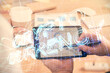 © peshkova - Double exposure of man's hands holding and using a phone and crypto currency blockchain theme drawing.