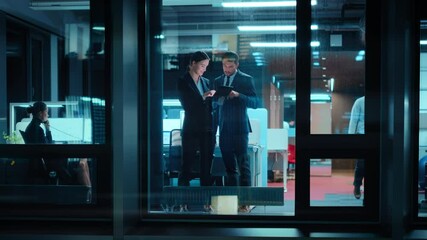 Poster - Footage from Outside: Businesswoman and Businessman in a Suit Working on a Tablet Computer in the Office. Manager Standing by the Window. Partners Talk about Financial and Business Development.