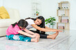 © ake1150 - Asian Mother and daughter doing fitness exercises in living room at home to maintain physical and mental health and wellbeing get exercise into your daily routine while social distancing..