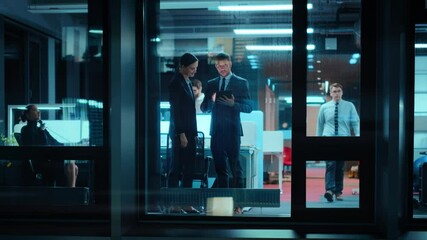 Poster - Footage from Outside: Businesswoman and Businessman in a Suit Working on a Tablet Computer in the Office. Manager Standing by the Window. Partners Chat about Financial and Business Development.