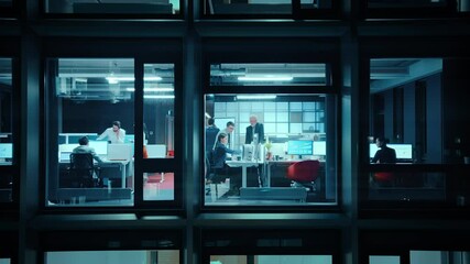 Poster - Footage from Outside the Window: Businessmen and Businesswomen Working in the Office. Managers and Specialists Doing Financial Business in the Evening. Employees Work on Computers and Delegate Tasks.