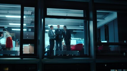 Poster - Footage from Outside the Window: Daily Meeting in the Office. Senior Manager Explaining New Business Strategy to Young Financial Specialists on a Laptop Computer while Standing Next to a Window.