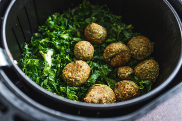 Wall Mural - plant-based food, falafels and kale chips in air fryer