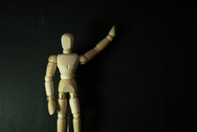 Wooden Mannequin Chasing Pointing Up On Black Background