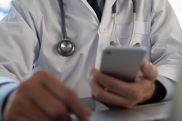 Wall Mural - Male doctor using mobile phone working in medical office