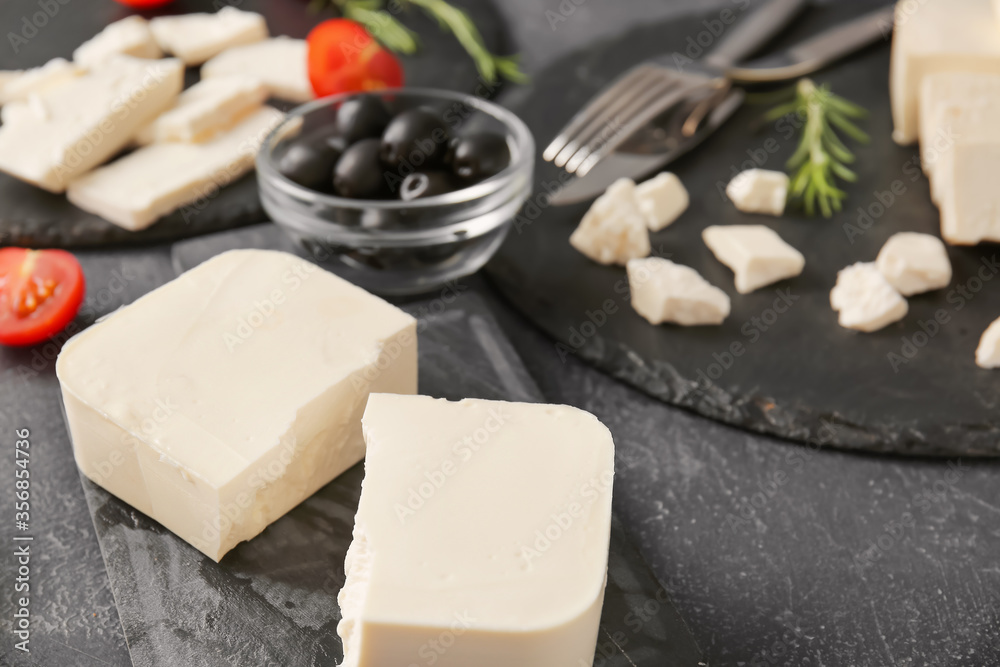 Tasty feta cheese on dark background