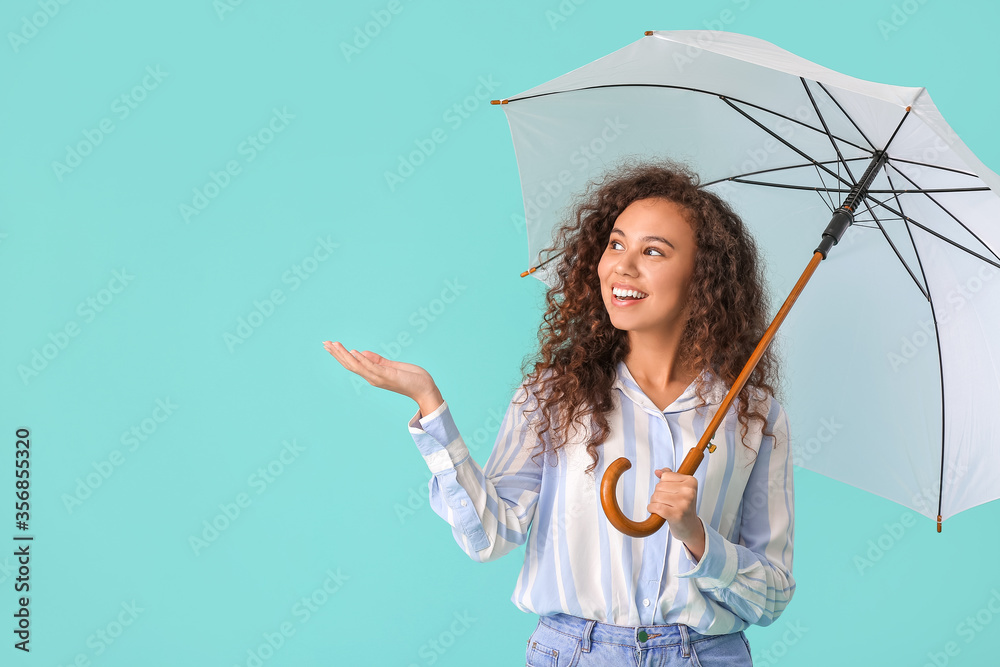Beautiful young woman with umbrella on color background