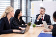 © Seksan - Ethnic diversity office staff and ceo boss are meeting consulting together in high floor office.