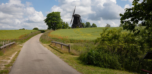 Old mill sitting on top of a hill with blue sky