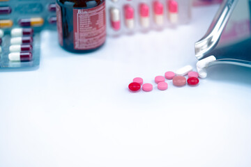 Poster - Red, pink, and white tablets pills with drug tray on blurred glass drug bottle and blister pack. Cracked tablets pills. Expired drugs. Painkiller medicine. Pharmacy shop. Pharmaceutical industry.