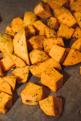 Homemade raw ready to cook sweet potato cubes with  herbs and olive oil. Raw sweet potatoes.