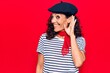 © Krakenimages.com - Middle age beautiful woman wearing french beret smiling with hand over ear listening and hearing to rumor or gossip. deafness concept.
