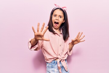 Sticker - Beautiful child girl wearing casual clothes afraid and terrified with fear expression stop gesture with hands, shouting in shock. panic concept.