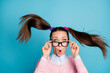 Portrait of astonished school girl look unexpected graduation exam news touch spectacles impressed haircut fly air wear good look clothes isolated over blue color background