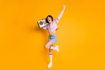 Poster - Full length body size view of her she nice attractive slender skinny cheerful cheery ecstatic girl carrying boombox having fun dancing isolated on bright vivid shine vibrant yellow color background