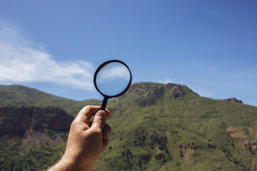 Wall Mural - Magnifying glass looks at mountains
