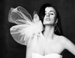 © Dmitry Lobanov - Black and white portrait of young beautiful brunette woman in white vintage dress with unusual decoration and earrings