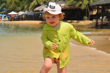 Happy caucasian child on a sandy beach in summer lifestyle. The concept of leisure activity, tourism and happy vacation