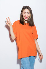 Wall Mural - Cheerful smiling girl showing peace sign isolated on white background