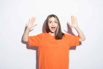 Wall Mural - Close-up portrait of surprised beautiful girl holding her head in amazement and open-mouthed over white background.