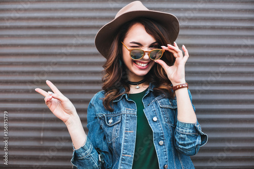 Cuadros en Lienzo Fashion, beautiful brunette in brown hat, making duck face and showing peace by two hands