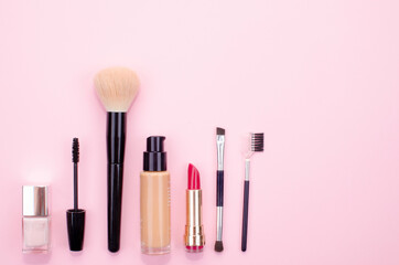 Makeup accessories on a pink background located at the bottom left of the image.